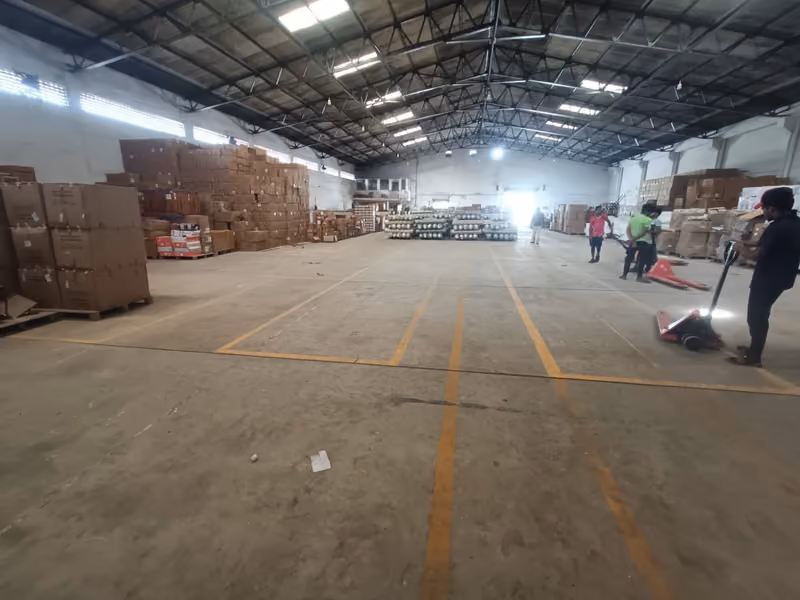 Inside Sanguine’s Chennai warehouse: palletised cartons along the walls and a clear marked aisle